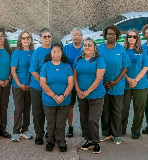 Merry maids standing in front of branded vehicles
